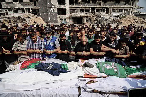 Palestinians pray over the bodies of journalists, including Al Jazeera correspondents Anas al-Sharif and Mohamed Qreiqeh, who were killed in an Israeli airstrike, during their funeral outside Gaza City's Shifa hospital complex, Monday, Aug. 11, 2025.