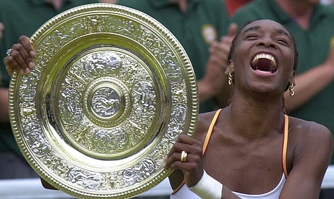 Venus Williams laughs as she holds the Women's Singles trophy on the Centre Court at Wimbledon Saturday, July 8, 2000.