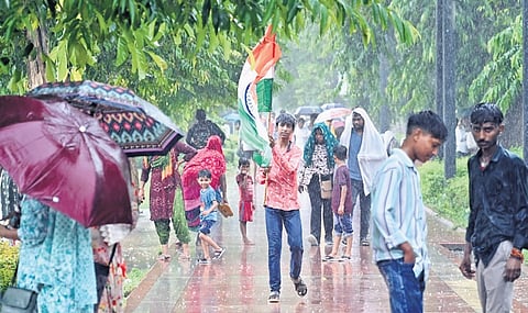A view of commuters during the heavy rain in New Delhi on Friday