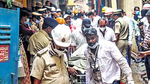 Firemen and volunteers carry out rescue operations from the plastic articles manufacturing unit, where a fire broke out, in Nagarathpete, in Bengaluru on Saturday