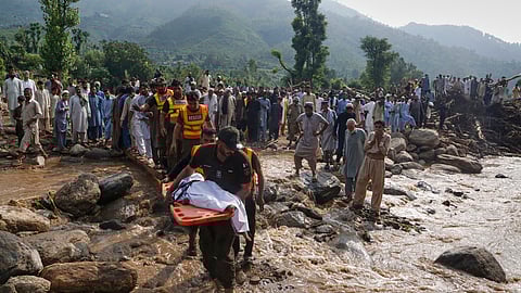 Rescue workers transport the body a victim of Friday's flash flooding after recovering it from the rubble of a damaged house at Qadir Nagar village near Pir Baba, Buner district, in Pakistan's northwest, Saturday, Aug. 16, 2025.