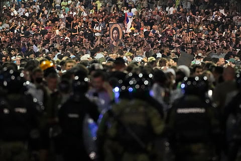 Serbian gendarmerie officers guard a street during an anti-government protest near the Serbian Progressive Party office in Belgrade, Serbia, Friday, Aug. 15, 2025.