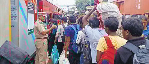 Passengers rush to board KSR  Bengaluru - Kanyakumari Express at T’Puram Central Railway Station on Sunday