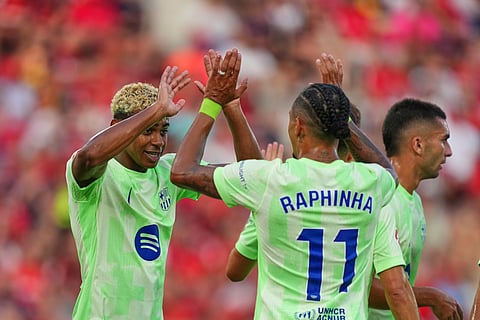 Barcelona's Lamine Yamal left, and Raphinha celebrate after a goalduring the La Liga soccer match between Mallorca and Barcelona in Mallorca, Spain, Saturday, Aug. 16, 2025.