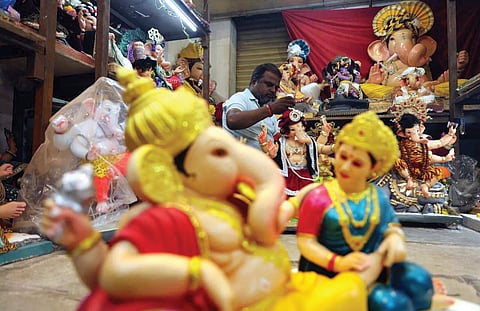 A vendor gives final touches to PoP idols of Lord Ganesha, brought from Maharashtra, at his shop in Dhoolpet, Hyderabad