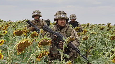 In this photo provided by Ukraine's 65th Mechanised Brigade press service, recruits practise military skills on a training ground in a sunflower field in the Zaporizhzhia region, Ukraine, Monday, Aug. 11, 2025.