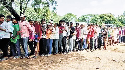Farmers wait in a queue for urea in Kuravi of Mahbubabad district on Thursday