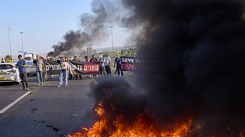Demonstrators block a road during a protest demanding the immediate release of hostages held.