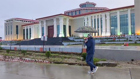Uttarakhand Chief Minister Pushkar Singh Dhami taking a Thursday morning stroll with an umbrella in the rain near the Bhararisain Assembly building in Gairsain.
