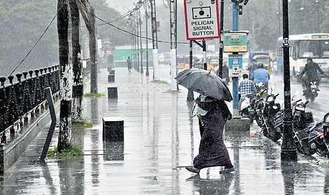 A woman uses an umbrella to shield herself from drizzle in Hyderabad on Tuesday.