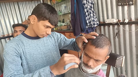 Lifter Yash Khandagale working at his father Vinod's hair saloon