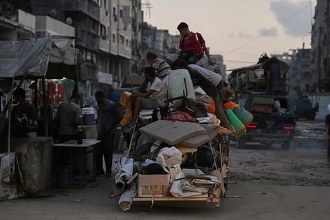 Displaced Palestinians fleeing Jabaliya move with their belongings on a street in Gaza City, Tuesday, Aug. 26, 2025.