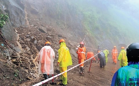 Fire and Rescue Services officials tying barricade tapes at the landslip-hit area