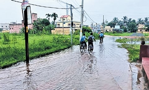 Students going to school on waterlogged road at Jagannath Vihar near Gopalpur in ward no.57.