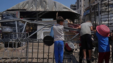 A Palestinian children wait at a community kitchen before donated food is prepared and distributed in Gaza City, Friday, Aug. 22, 2025.