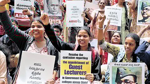 AIDSO members hold placards demanding immediate appointment of guest faculty at government colleges during a stir at Freedom Park on Friday
