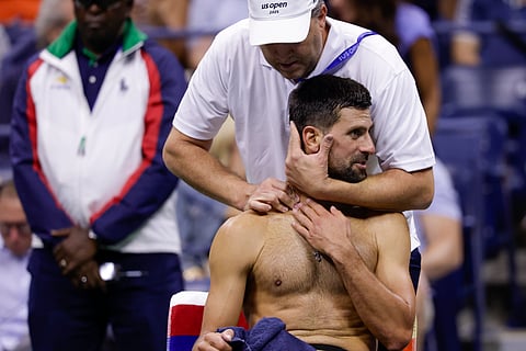 A trainer works on Novak Djokovic, of Serbia, between games against Jan-Lennard Struff, of Germany, during the fourth round of the U.S. Open tennis championships, Sunday, Aug. 31, 2025, in New York.
