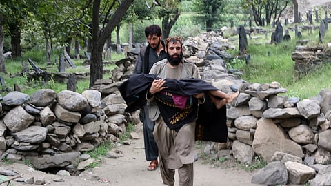 An injured person is carried to a military helicopter that landed to evacuate injured victims of an earthquake that killed many people and destroyed villages in eastern Afghanistan, in Mazar Dara, Kunar province, Monday, Sept. 1, 2025