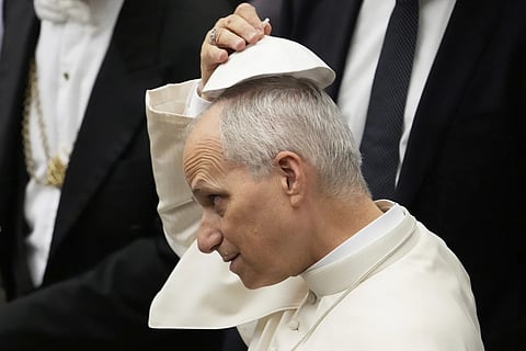 Pope Leo XIV tries a skull cap which was handed to him by faithful during the weekly general audience at the Vatican, Wednesday, Aug 27, 2025.