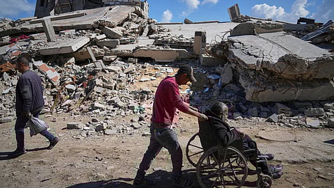 FILE - Wasem Attiya pushes his father, Mohamed, 54, in a wheelchair as they head to Shifa hospital in Gaza City for a dialysis session, Monday, April 14, 2025