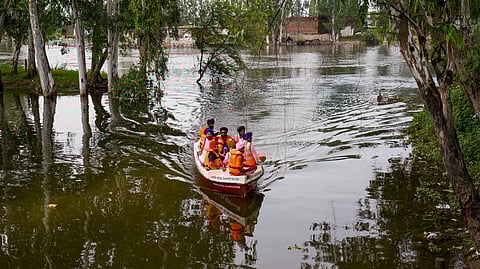 Officials inspect a flood-affected area in a boat, at Ajnala in Amritsar district, Punjab, Saturday, Sept. 6, 2025.
