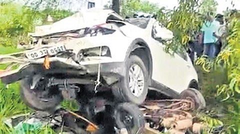 The mangled auto-rickshaw beneath the damaged car.