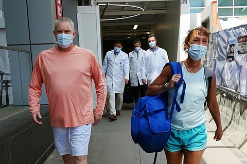 In this photo provided by Mass General Brigham, Bill Stewart, left, leaves the hospital with his wife, Sara, after being discharged, June 21, 2025, at Massachusetts General Hospital in Boston.