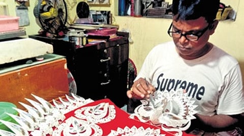 Silver filigree artist Pradip Kumar Prusty engaged in making Chandi Medha.