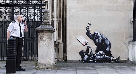 Undated photo released by Banksy of the new artwork by the artist which portrays a judge beating a protester with a gavel at the Royal Courts of Justice in London.