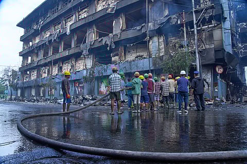People work to douse a fire at Bhatbhatini shopping center after it was vandalized in Kathmandu, Nepal, Wednesday, Sept.10, 2025.