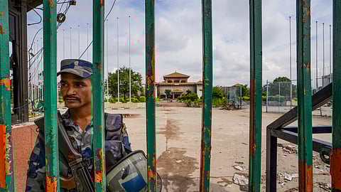 A security personnel keeps vigil in the premises of the vandalized Federal Parliament in the aftermath of anti-government protests, in Kathmandu, Nepal, Saturday, Sept. 13, 2025.