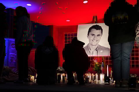 People place lit candles below a photo of Charlie Kirk, the CEO and co-founder of Turning Point USA who was shot and killed, at a vigil in his memory, Thursday, Sept. 11, 2025, in Orem, Utah.