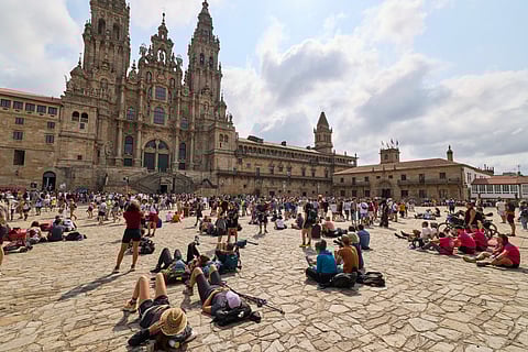 Pilgrims and tourists rest in front of the cathedral in Santiago de Compostela, northwestern Spain, Thursday, Aug. 21, 2025.