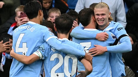 Manchester City's Norwegian striker #09 Erling Haaland (R) celebrates scoring their third goal during the English Premier League football match between Manchester City and Manchester United at the Etihad Stadium in Manchester, north west England, on September 14, 2025.