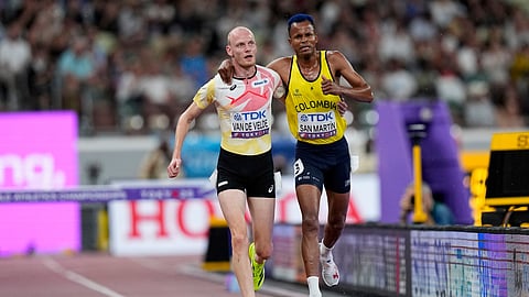 Colombia's Carlos San Martin and Belgium's Tim Van De Velde help each other to the nine during a men's 3,000 meters steeplechase heat at the World Athletics Championships in Tokyo, Saturday, Sept. 13, 2025.