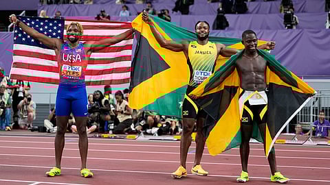 Jamaica's gold medalist Oblique Seville, right, and silver medalist Kishane Thompson, pose with bronze medalist United States' Noah Lyles, left, after competing in the men's 100 meters final at the World Athletics Championships in Tokyo, Sunday, Sept. 14, 2025.