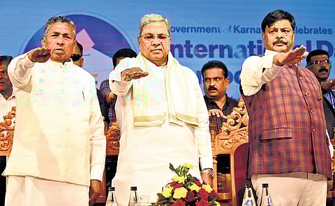 CM Siddaramaiah and ministers KH Muniyappa and HC Mahadevappa take a pledge at an event organised to mark the International Day of Democracy on Monday.