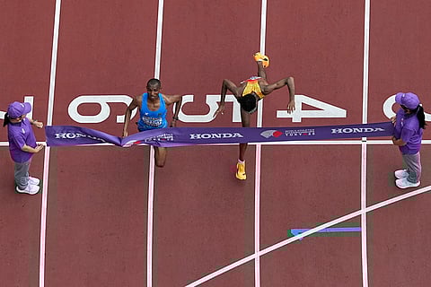 Tanzania's Alphonce Felix Simbu, left, crosses the finish line ahead of Germany's Amanal Petros to win the men's marathon at the World Athletics Championships in Tokyo, Monday, Sept. 15, 2025.
