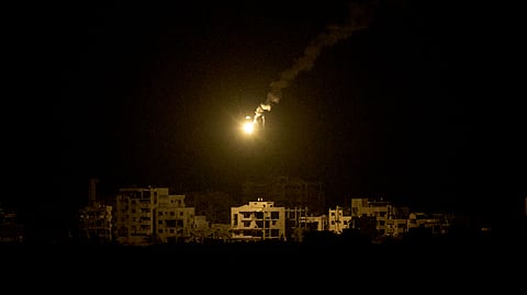 An Israeli army flare drifts over buildings destroyed during the Israeli ground and air operations in the northern Gaza Strip, as seen from southern Israel, Monday, Sept. 15, 2025.
