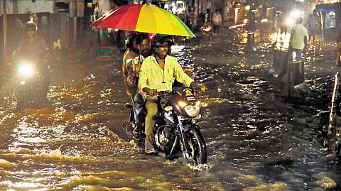 Commuters navigate a waterlogged road in Somajiguda.
