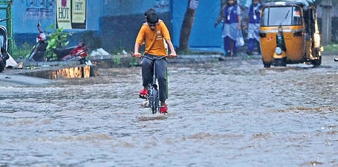 A boy rides his bicycle through a waterlogged road near the Secunderabad Railway Station on Thursday.