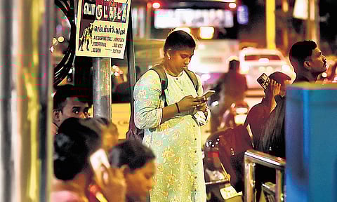 Youngsters seen checking their mobile at a bus stand in Nungambakkam.