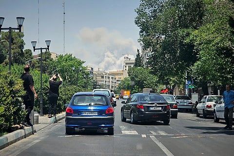 Residents record smoke rising from an Israeli strike in Teheran, Iran, June 23, 2025.