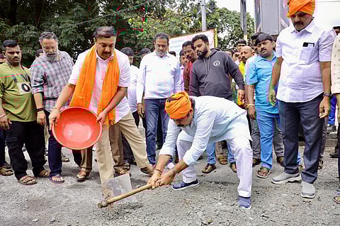 LoP R Ashoka fills a pothole in his constituency Padmanabhanagar in Bengaluru to protest against the state government over poor roads, on Wednesday.