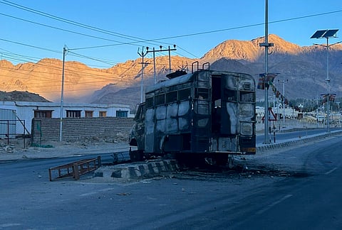 Charred remains of a vehicle lies in the middle of a deserted road, a day after violence erupted over statehood and other demands, in Leh, Ladakh, Thursday, Sept. 25, 2025.