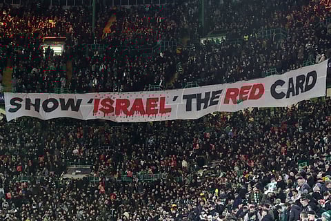 Celtic fans lift a protest banner about Israel during the Champions League playoff first leg soccer match between Glasgow Celtic and Bayern Munich at the Celtic Park Stadium in Glasgow, Scotland, Wednesday, Feb. 12, 2025.