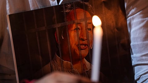 An agitator holds a poster and a candle during a protest condemning the arrest of climate activist Sonam Wangchuk, at Jantar Mantar, in New Delhi, Friday, Sept. 26, 2025.