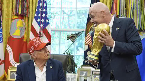 Donald Trump looking at the FIFA Worldcup trophy
