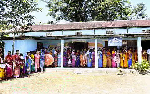 People stand in a queue to cast their votes for the Bodoland Territorial Council (BTC) elections at a polling centre near Urahiloga village, in Sonitpur, Sept. 22, 2025.