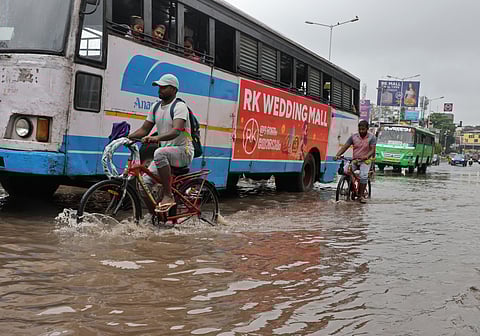 Commuters wade through waterlogged roads at the busy East Fort in Thiruvananthapuram on Friday, after heavy rain in recent days inundated major roads and low-lying areas.